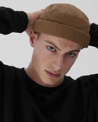 A stylish brimless cap in a natural outdoor setting.